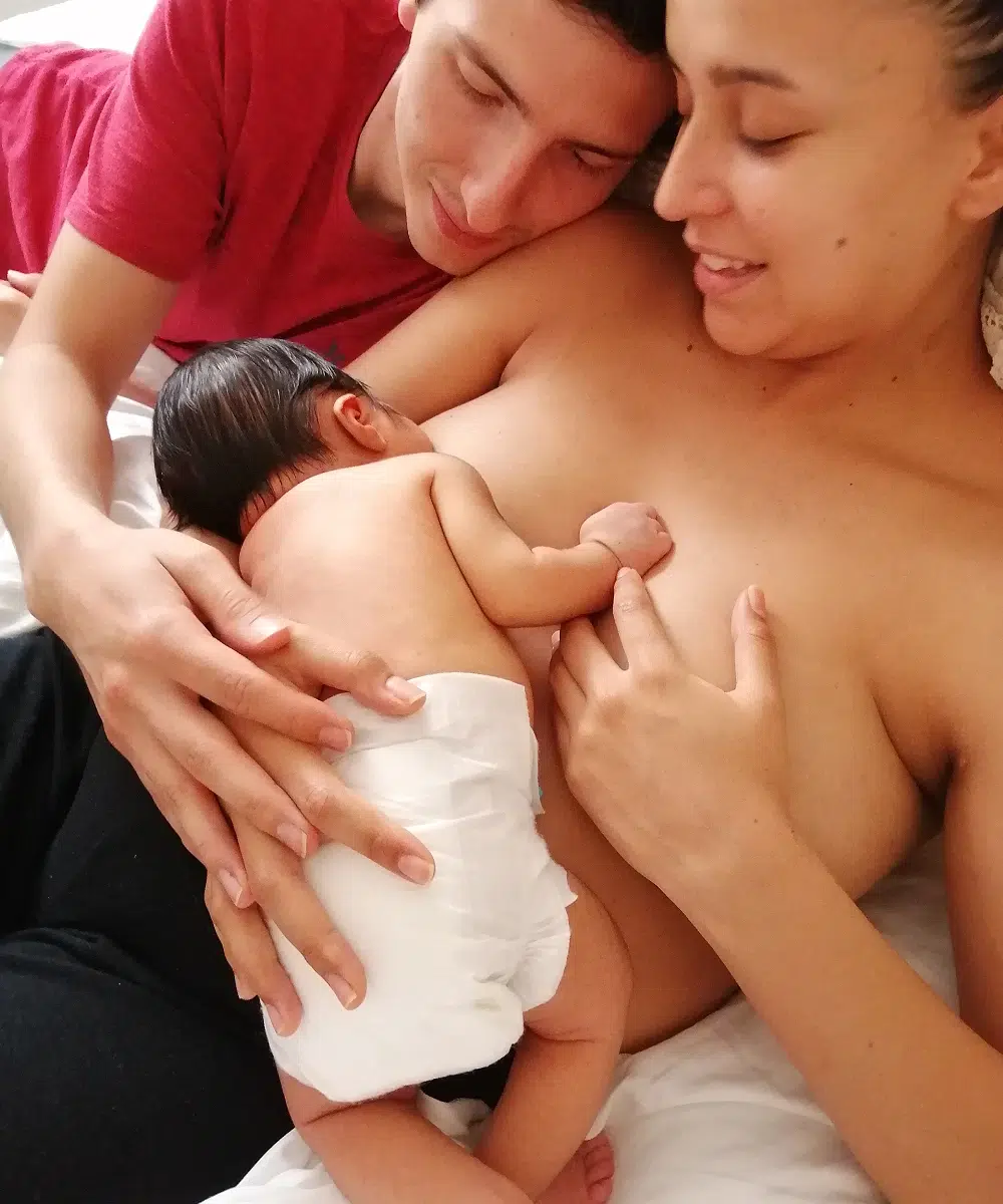 Parents avec un nouveau-né au lit